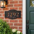Custom address metal sign with EATON, 3292 and EST 1974 cutouts in black hammertone paint, mounted beside a house front door.