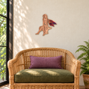 Gazing Fairy Metal Garden Decor in Copper with rainbow torched wings and directional grinding, displayed above a rattan chair in an indoor garden reading corner.