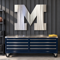 Michigan Block M polished metal wall art above a navy tool chest in a garage.
