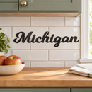 Michigan Metal Wall Art in Matte Black, displayed at its actual small scale in a coordinated indoor setting.