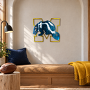 Michigan Wolverines Logo Metal Wall Art in Airbrushed Maize & Blue, displayed in an indoor college-football fan setting.