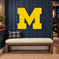 Michigan Wolverines block M Metal Wall Art in Yellow, displayed in a coordinated indoor Michigan fan space.