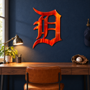 Old English D Metal Wall Art in Airbrushed Orange, displayed in an indoor baseball fan setting.