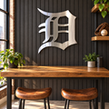 Old English D Metal Wall Art in Polished Metal, displayed in an indoor baseball fan setting.
