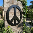 Full view of peace symbol metal wall art mounted outdoors, showcasing size, placement, and protective coating in natural sunlight.