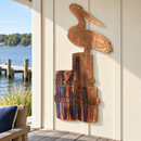 Pelican On A Stump metal wall art in Copper Bronze mounted on an outdoor boathouse porch overlooking a lake and dock.