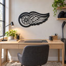 Winged Wheel Metal Wall Art in Black, displayed in an indoor hockey fan setting.